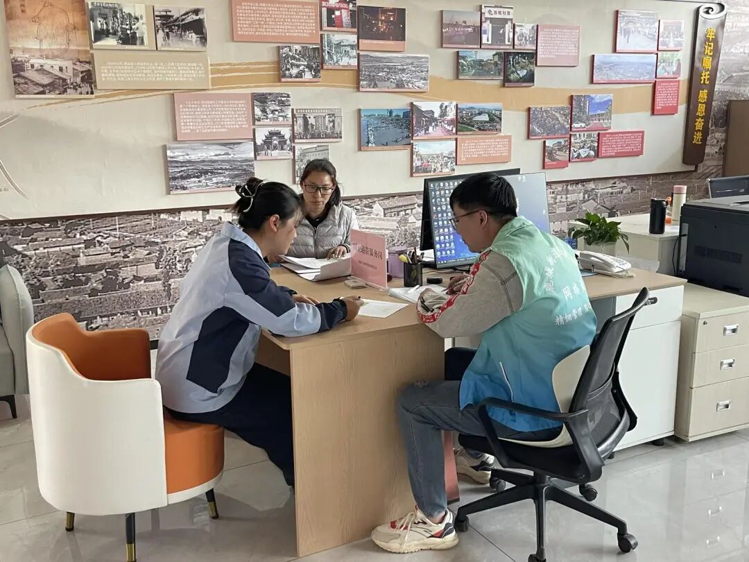 丁晓玲和社区工作人员讨论居民诉求